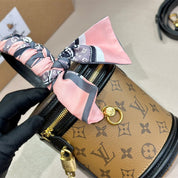 Modische Handtasche aus bedrucktem Leder mit buntem Riemen und Umhängetasche